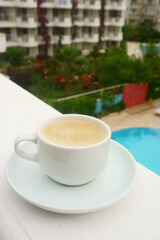 Cup of  coffee  on the background of the pool