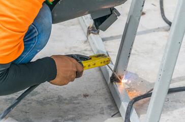 Welder works on the building of a house
