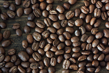 Coffee beans over the black wooden background