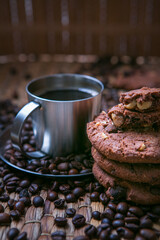 coffee cup and coffee beans on wooden table with cookies