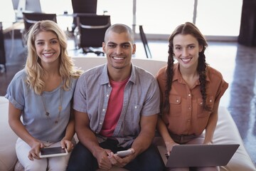 Smiling business colleagues holding laptop