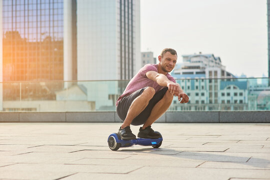 Young male riding hoverboard. Man in the city, daytime.