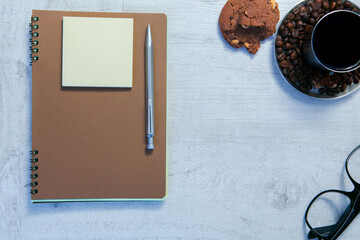 Blank spiral notepads, Cup of Coffee and Pen on Wood Background
