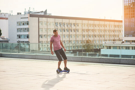 Man on a hoverboard. Young male, daytime city background. Inventions that change our life.