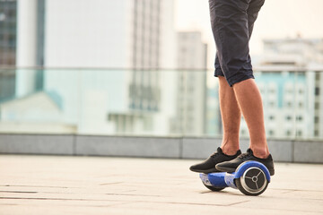 Legs of man riding gyroboard. Person on blue hoverboard. Facts about hoverboards.