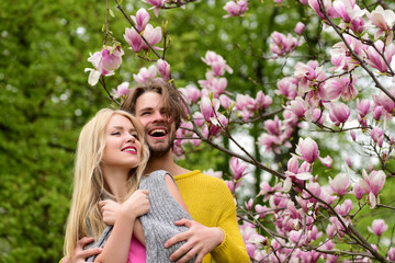 romantic couple in love in spring garden at blooming magnolia