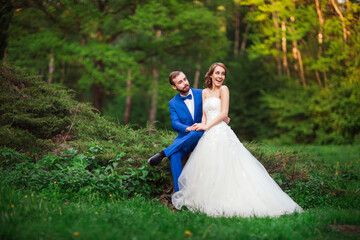 Young couple groom and bride walk in the Park. The bride and groom laugh.