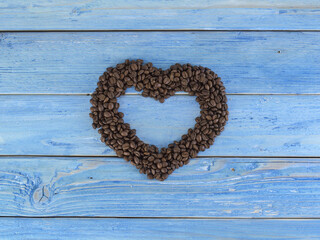 Natural coffee beans on a blue wooden board. 