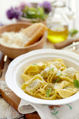 Tortellini stuffed basil pesto sprinkled with parmesan cheese and fresh basil