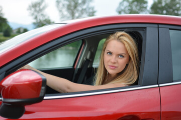 Young girl driving red car