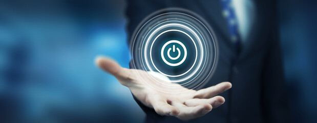Businessman on blurred background holding render power button with his hand
