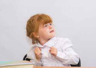 The little girl at the table looking up frightened