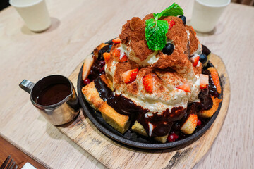 honey toast on hot pan toppings with strawberries whipped cream and chocolate