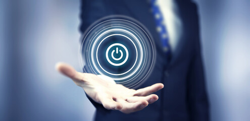 Businessman on blurred background holding render power button with his hand