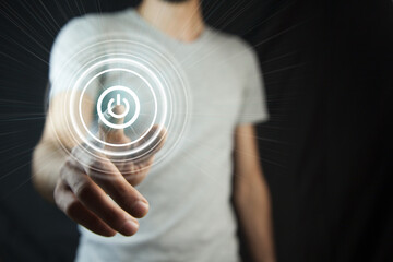 Businessman on blurred background holding render power button with his hand