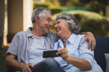 Cheerful senior couple looking at each other in backyard