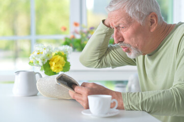 Beautiful old man reading a newspaper