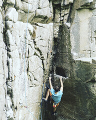 A young man climbs in a canyon.