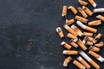 Cigarette butts on a black background with space for text
