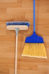 Two sweeping brooms on wooden floor