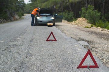 Repairman near broken down car