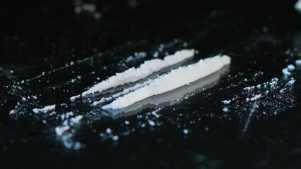 Drug Abuse. A rolled banknote snorting two lines of cocaine powder. Problems with drugs concept. Black background. Close-up macro shot. - Powered by Adobe