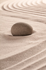 Fototapeta na wymiar Purity concept by round stone on raked sand in zen meditation garden.