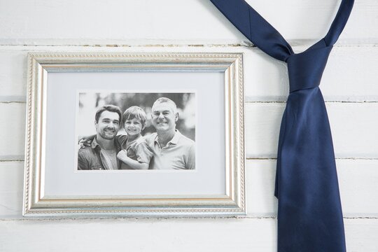 Close up of picture frame hanging by necktie on wall