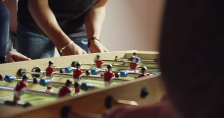 multiethnic group of friends and child playing table football. indoor in modern industrial house. 4k handheld slow motion detail video shot - Powered by Adobe