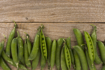 Green peas on a wooden background