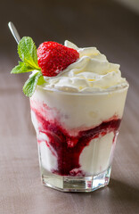 Ice cream with topping and berries in a glass