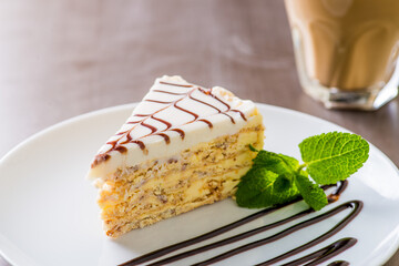 piece of cake served on a white plate with a cup of coffee