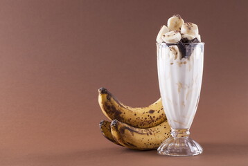 Milkshake with banana and chocolate on a brown background
