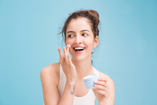 Woman with cream on blue background