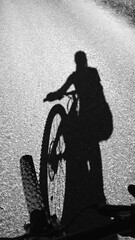 Fototapeta na wymiar Shadow of a woman cyclist and a bicycle on the road. Slovakia