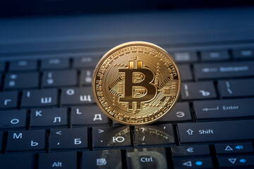 gold bitcoin coin on the keyboard. close up