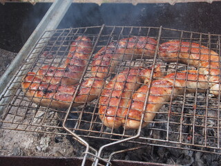 Cooking sausages on the grill. Lunch in the nature.