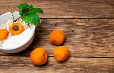 Muesli of oatmeal and fruit on a wooden table, concept of dietary nutrition.