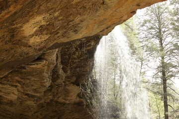The waterfall at Ash Cave in Hocking Hills State park pouring over the ledge above. © Margaret Burlingham