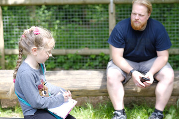 A girl and a man are sitting on the playground