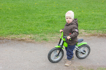 A child riding a Bike without the pedal. A little boy learns to ride the streets on cross-country bike..