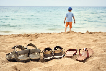 Three pairs of sandals on the beach sand. Its belong to father, mother and child The view to the sea. - 157327684