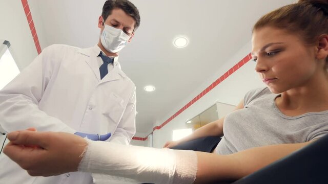 A professional doctor is putting a bandage on a girl's arm
