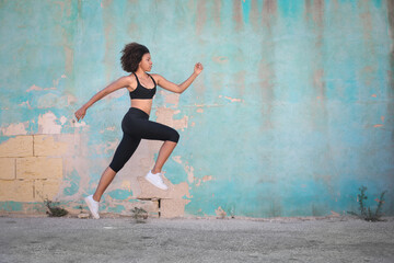 Workout in the street, in front of a light blue wall