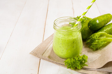 Healthy green smoothie in jar with cucumber, salad and spices