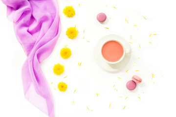 Composition with yellow flowers, cup of yogurt and macaroons on white background. Top view, flat lay