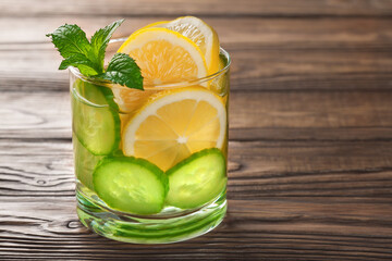 cool drink with lemon and mint on a wooden background
