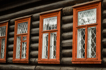 Ancient house of logs of the twentieth century in Russia, Russian wooden house with orange window frames