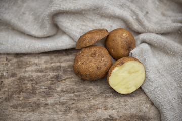 potatoes in burlap on the wooden background
