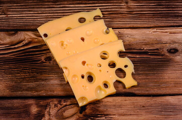Sliced cheese on wooden table. Top view